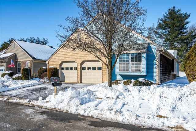 a front view of a house with a yard covered in snow