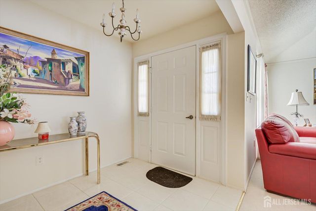 a dining room with furniture a chandelier and window