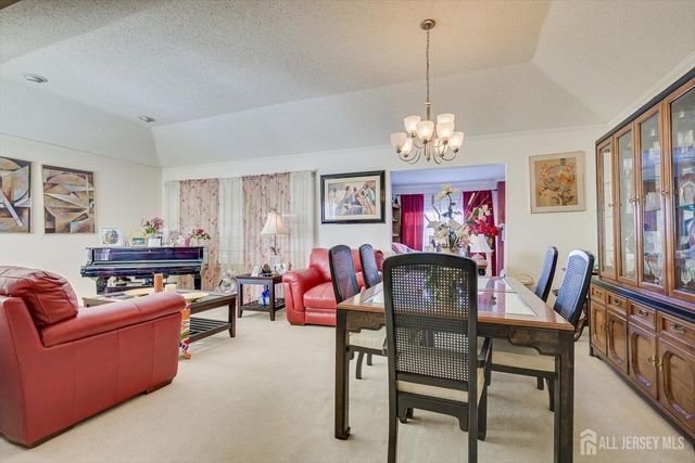 a view of a dining room with furniture a livingroom and chandelier