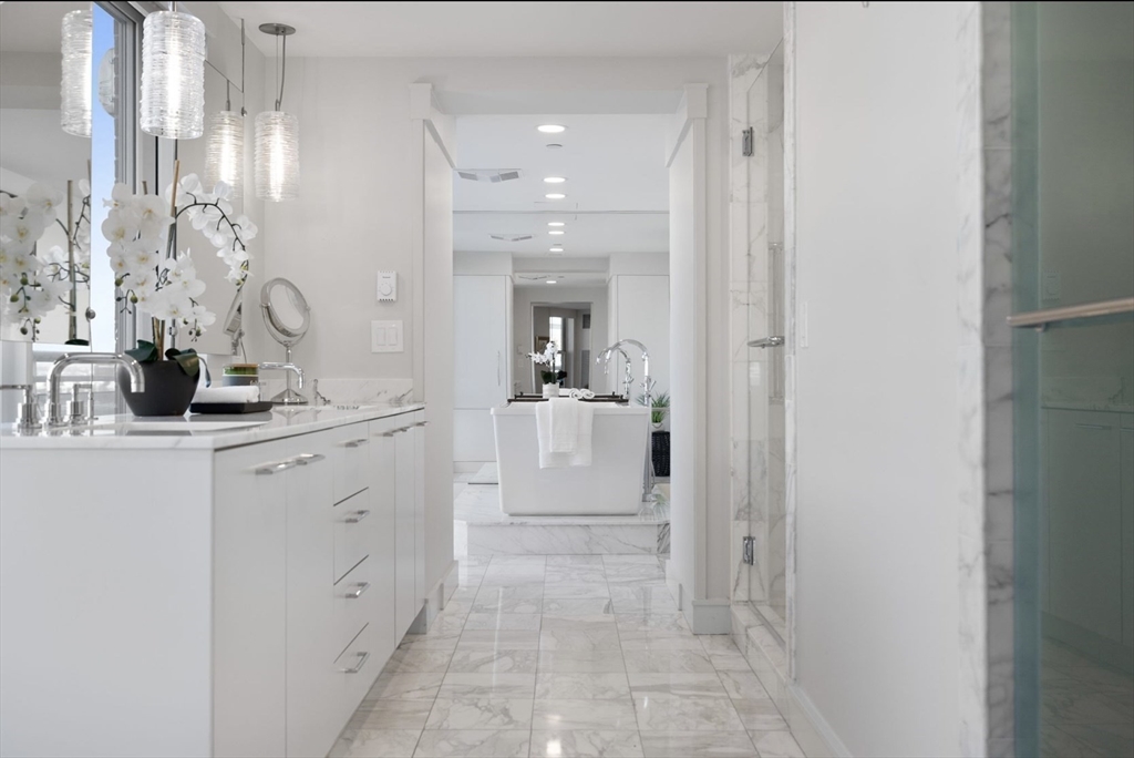 4 Battery Wharf, Unit PH 46 Boston, MA 02109 - Photo 28 of 39 a bathroom with sink mirror and cabinets