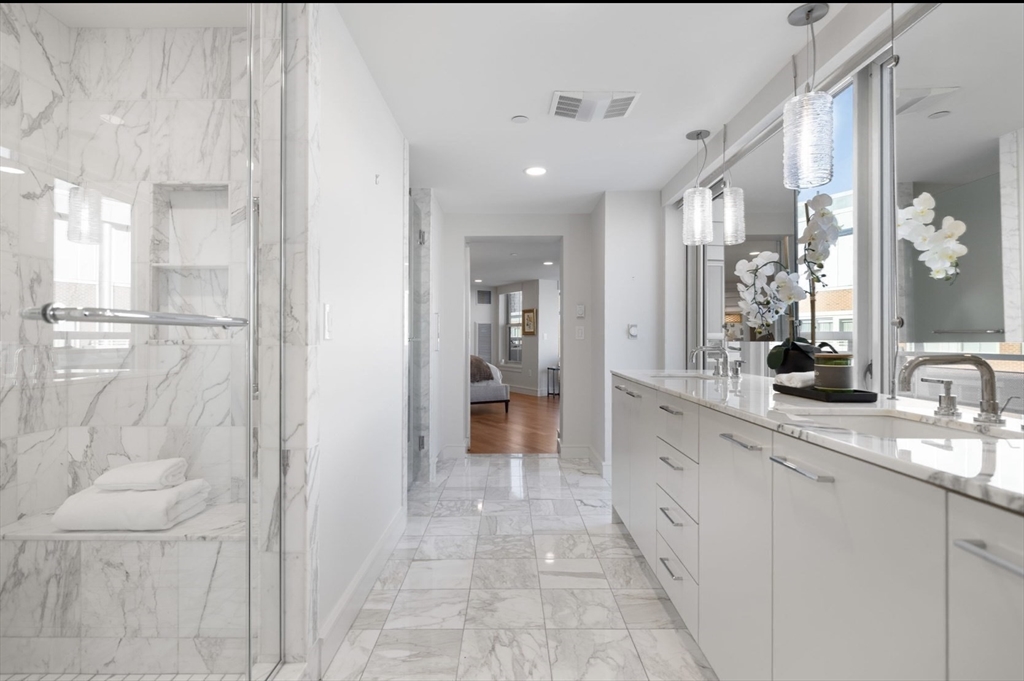 4 Battery Wharf, Unit PH 46 Boston, MA 02109 - Photo 30 of 39 a large white bathroom with a granite countertop sink mirror and shower