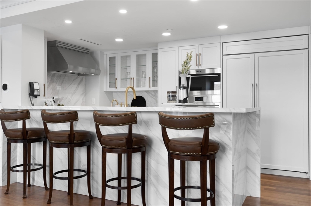 4 Battery Wharf, Unit PH 46 Boston, MA 02109 - Photo 9 of 39 a kitchen with stainless steel appliances granite countertop a table chairs and a refrigerator