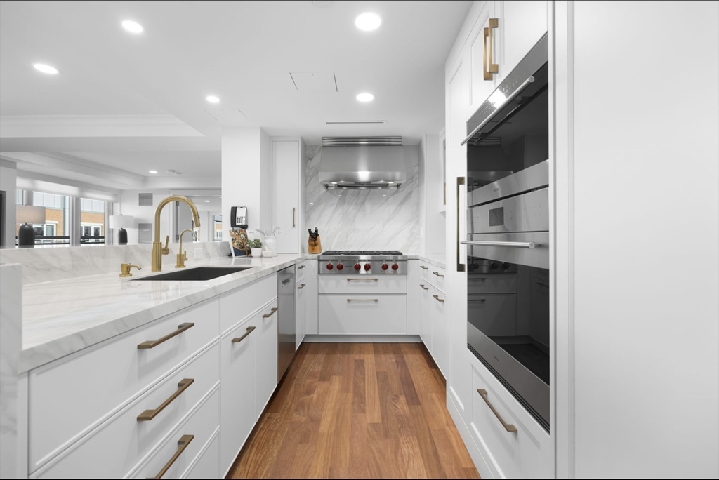 4 Battery Wharf, Unit PH 46 Boston, MA 02109 - Photo 10 of 39 a large kitchen with stainless steel appliances kitchen island granite countertop a large counter top a sink and a stove