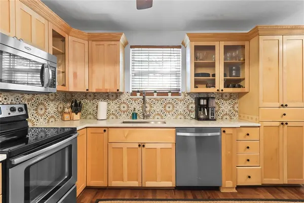 a kitchen with stainless steel appliances granite countertop a sink a stove and cabinets