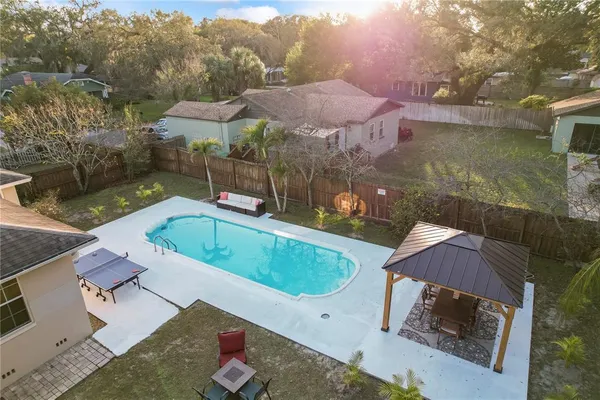 an aerial view of a house with swimming pool and a yard