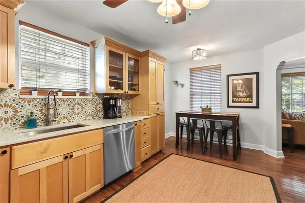 a kitchen with stainless steel appliances granite countertop a stove a sink a dining table and chairs