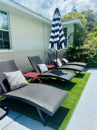 a view of a roof deck with couches chairs and a yard
