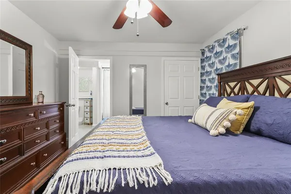 a spacious bedroom with a bed and a dresser