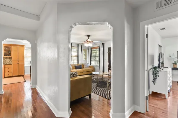 a view of a hallway with wooden floor fireplace and living room