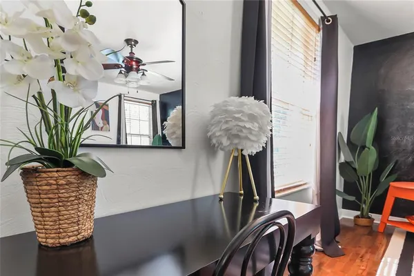 a dining room with furniture and potted plants