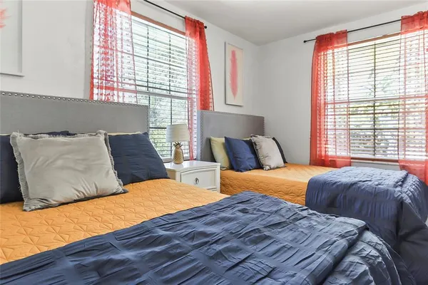 a bedroom with two beds and a large window