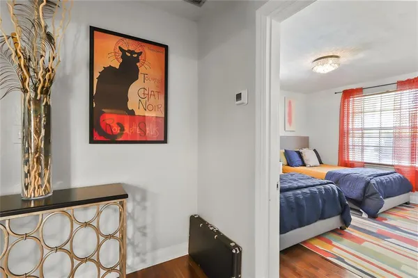 a bedroom with two beds and a painting on the wall