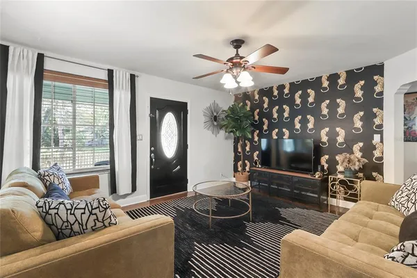 a living room with furniture a flat screen tv and a large window