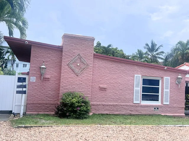 a front view of a house with a yard and potted plants