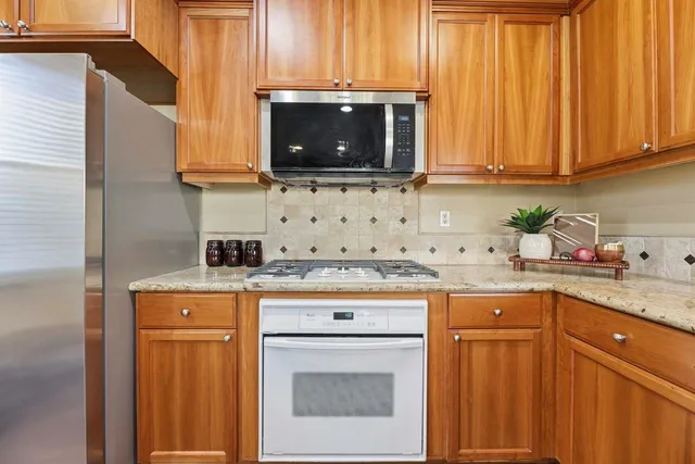 a kitchen with stainless steel appliances granite countertop a sink stove and microwave