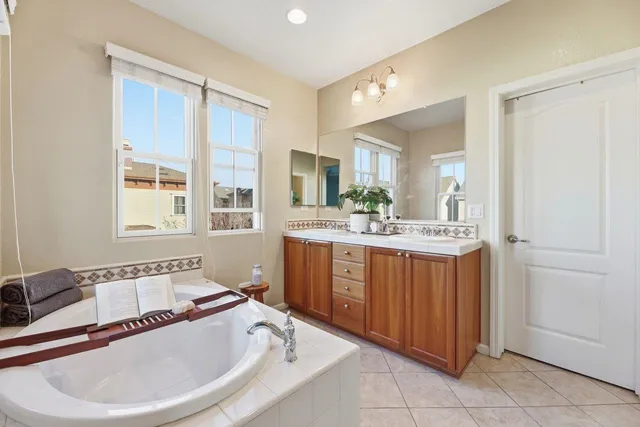 a bathroom with a tub sink and mirror