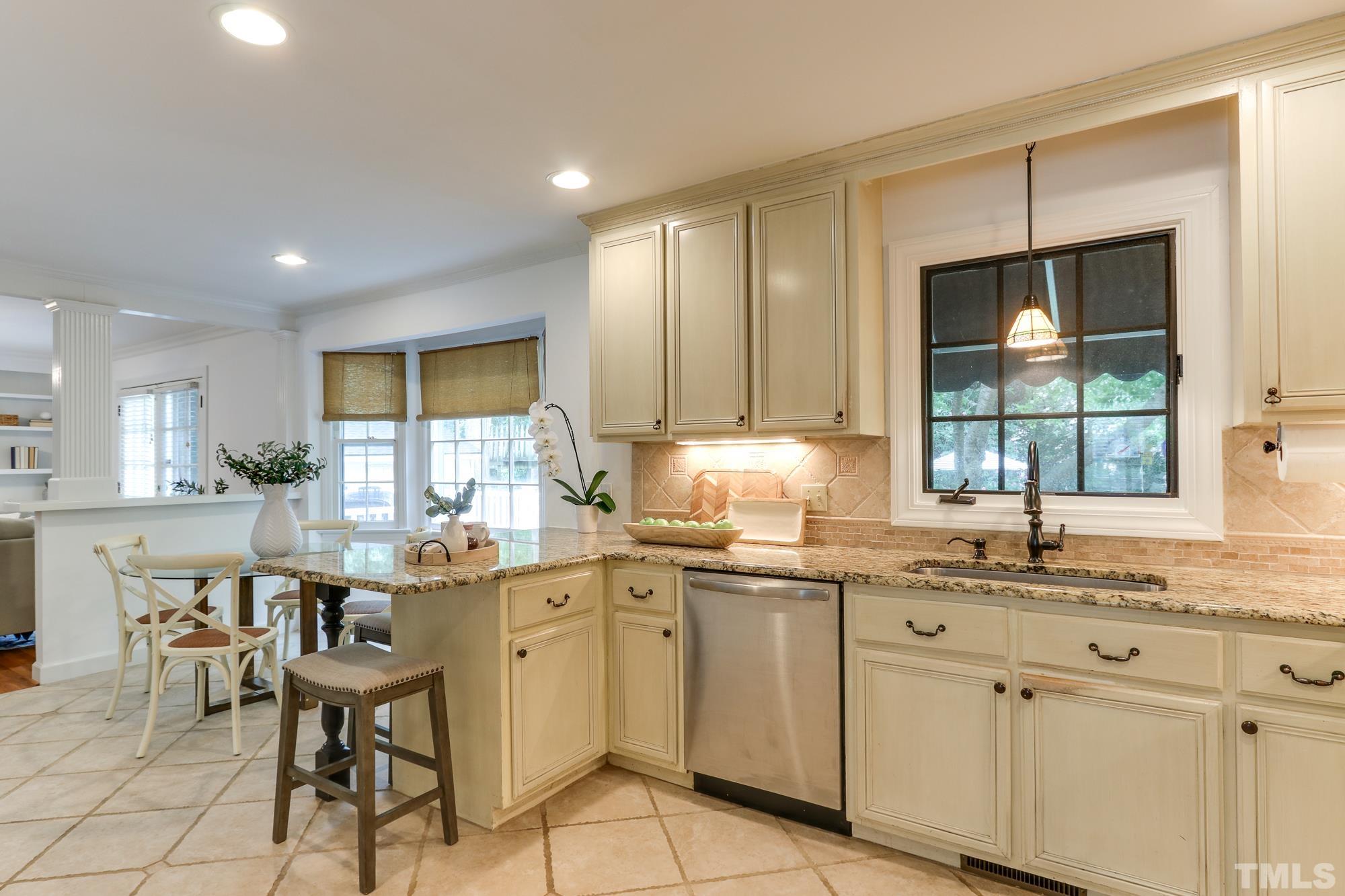 8913 Lindenshire Road Raleigh, NC 27615 - Photo 12 of 27 a kitchen with a sink window and cabinets