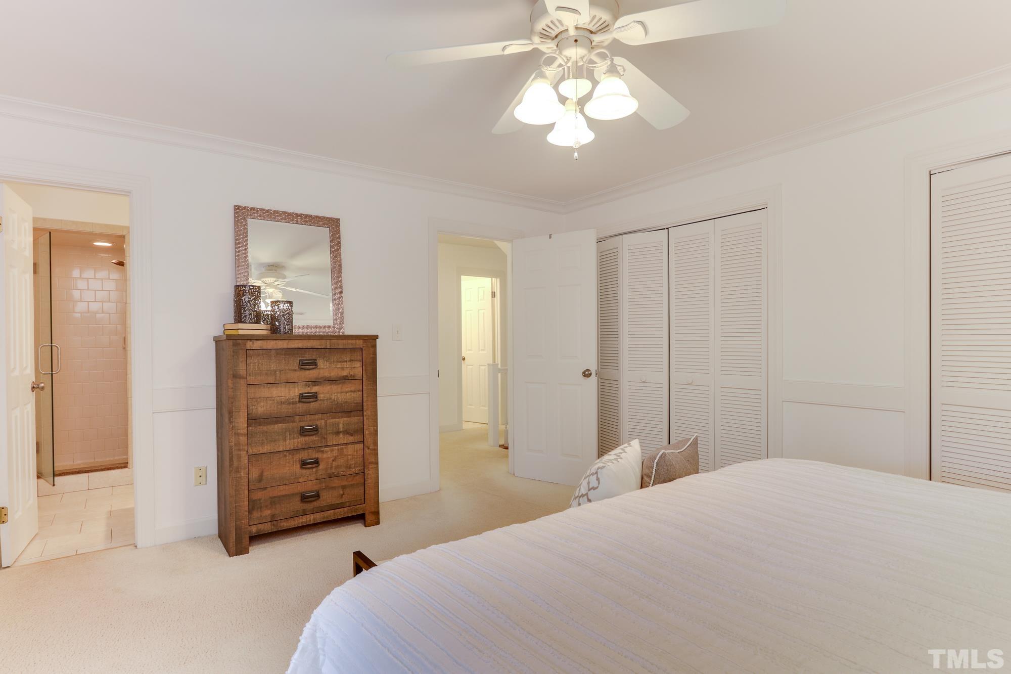 8913 Lindenshire Road Raleigh, NC 27615 - Photo 15 of 27 a bedroom with a bed and a chandelier