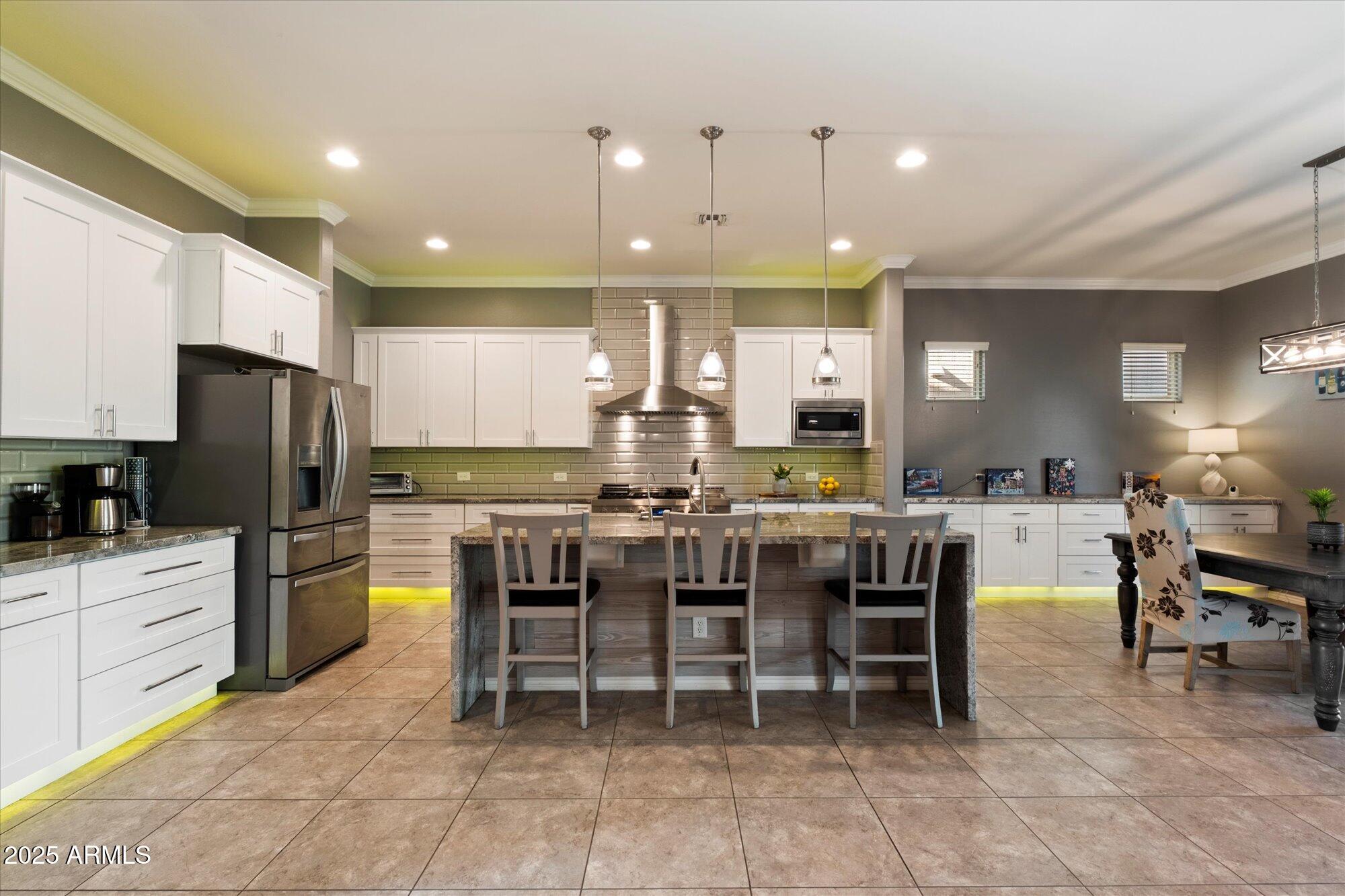 5123 South Mariposa Drive Gilbert, AZ 85298 - Photo 3 of 35 a kitchen with a dining table chairs and refrigerator