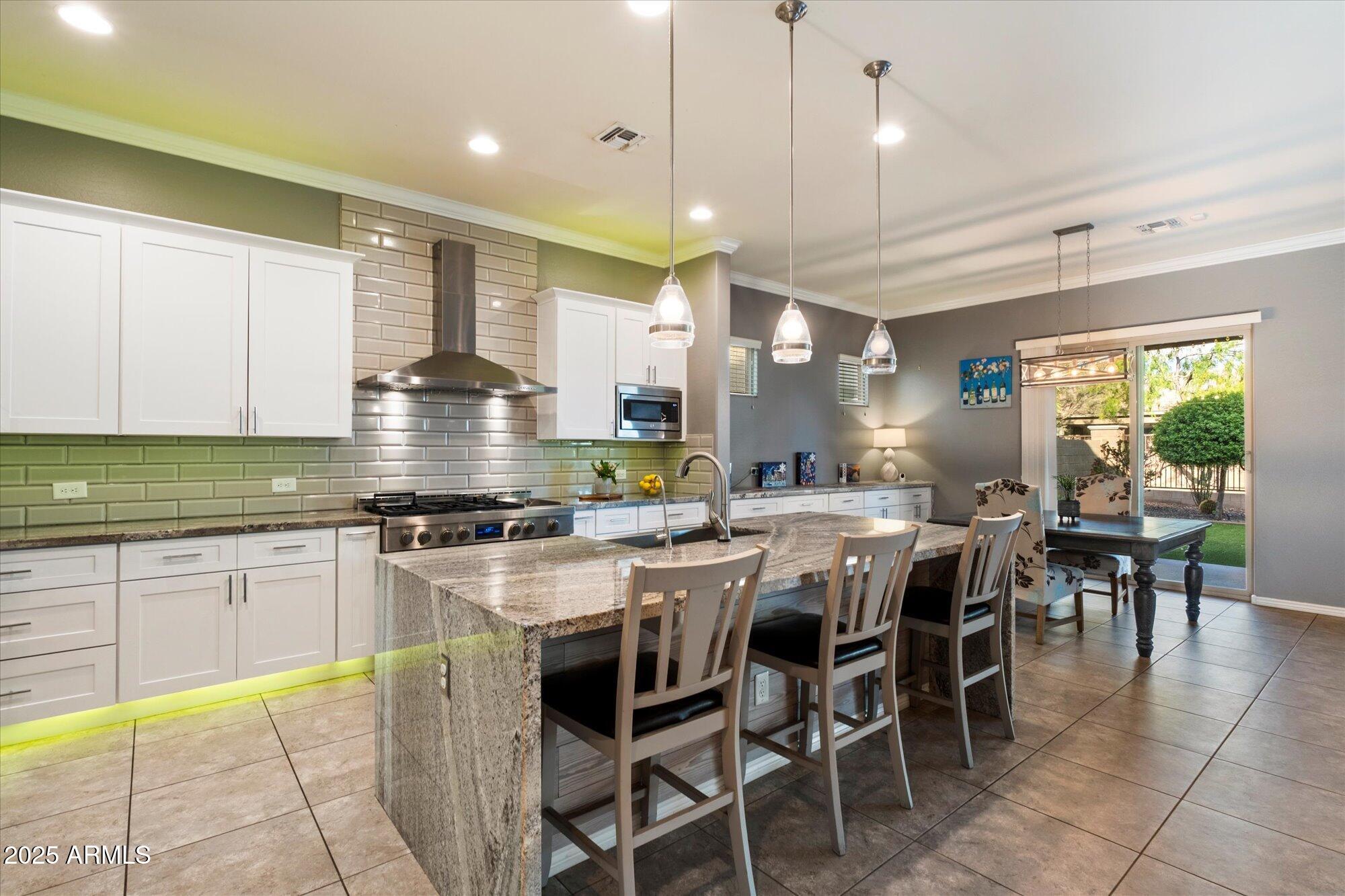 5123 South Mariposa Drive Gilbert, AZ 85298 - Photo 4 of 35 a kitchen with lots of counter space dining table and stainless steel appliances