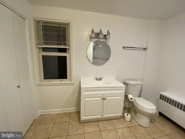 a bathroom with a toilet a sink and mirror