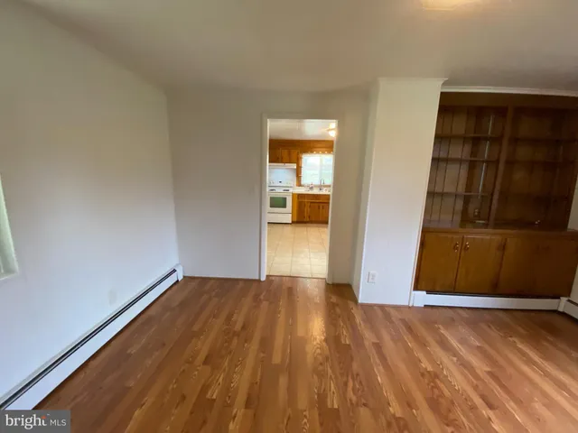 a view of empty room with wooden floor and cabinet