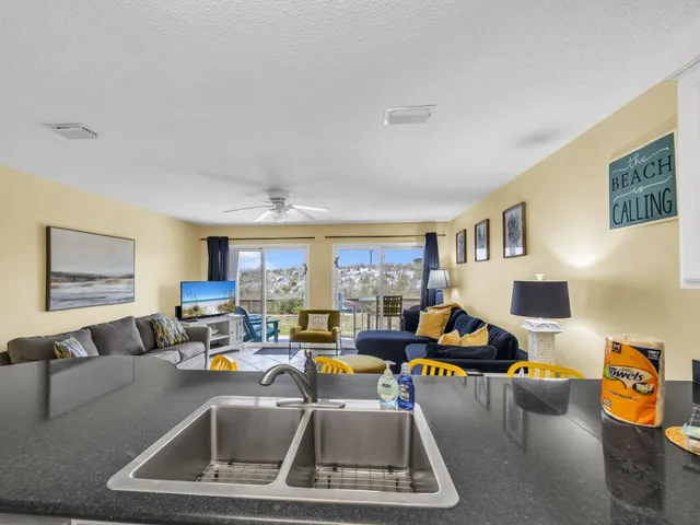 a living room with furniture kitchen view and a window