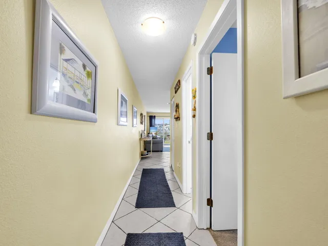 a view of a hallway with windows and a livingroom