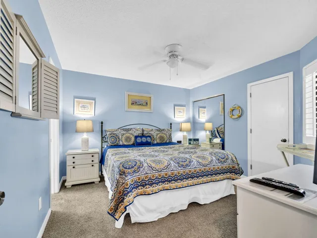 a bedroom with a bed and a lamp on the dresser