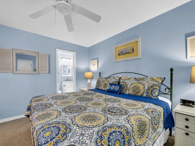 a bedroom with a bed and a lamp on dresser