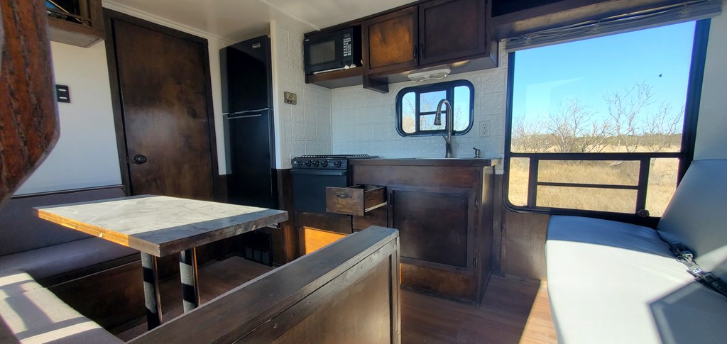 54 Dry Creek Road, Unit 54 Fort McKavett, TX 76841 - Photo 14 of 16 a kitchen with stainless steel appliances wooden cabinets a refrigerator and a table