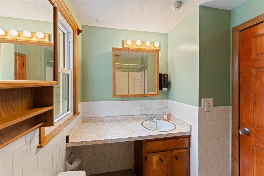 38 Orton Street Worcester, MA 01604 - Photo 18 of 37 a bathroom with a granite countertop sink and a mirror
