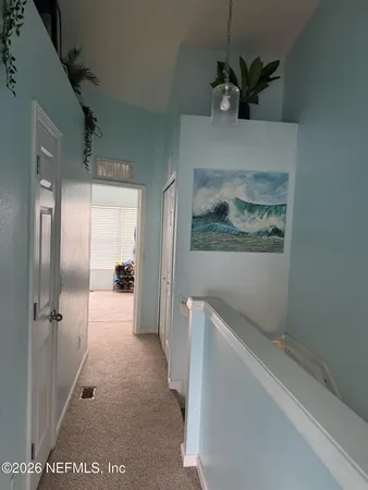 a view of hallway with chandelier fan and wooden floor