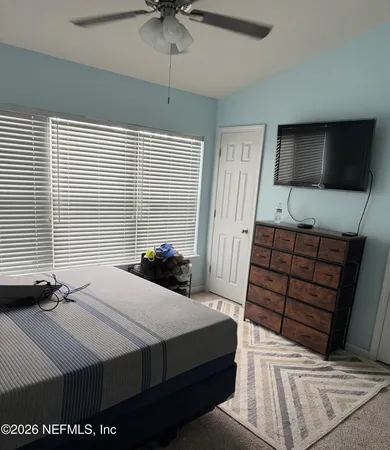 a bedroom with a bed and a flat screen tv