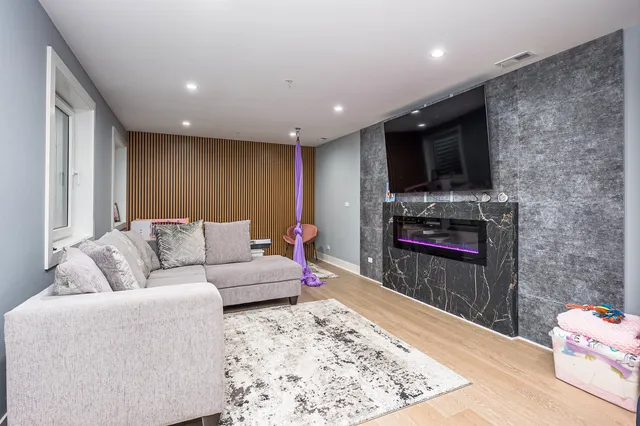 a living room with furniture a flat screen tv and a fireplace