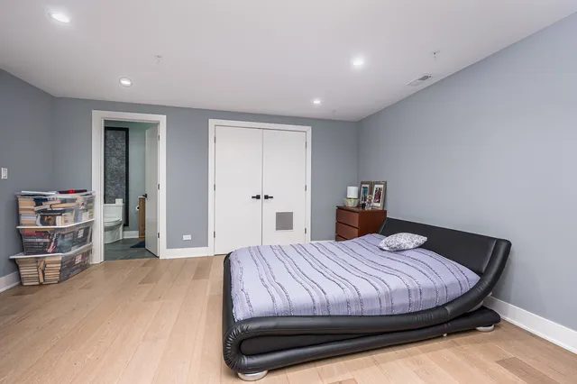 a spacious bedroom with a bed and a book shelf