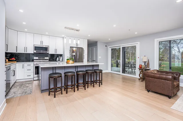 a living room with furniture and a dining table with kitchen appliances