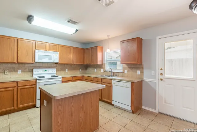 a kitchen with a sink stove and cabinets