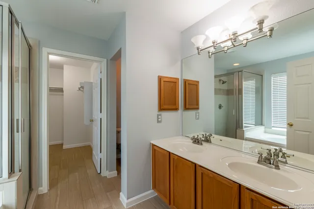 a bathroom with a double vanity sink a mirror and a shower