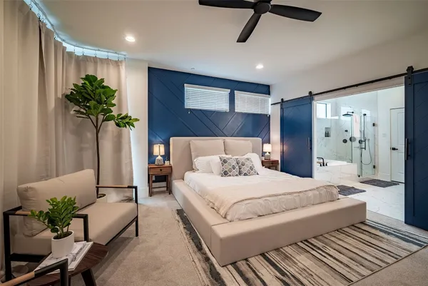 a spacious bedroom with a large bed and a chandelier