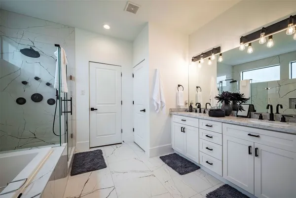 a bathroom with a tub a sink shower and mirror