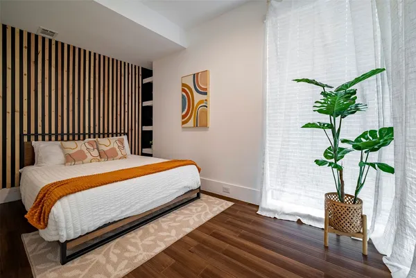a bedroom with bed and a potted plant