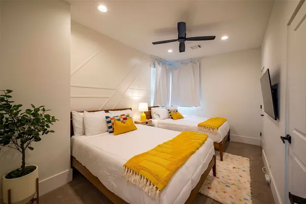 a bedroom with a bed and a potted plant