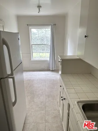 a kitchen with stainless steel appliances a refrigerator sink and cabinets