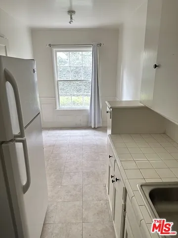 a kitchen with stainless steel appliances a refrigerator sink and cabinets