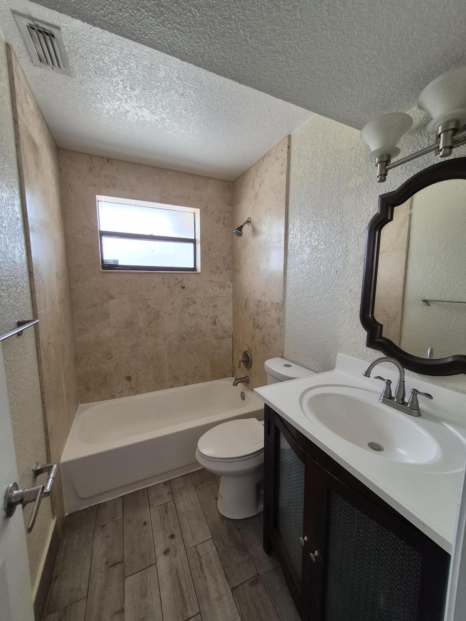 10039 Winding Lake Road, Unit 202 Sunrise, FL 33351 - Photo 10 of 14 a bathroom with a sink a toilet and a mirror