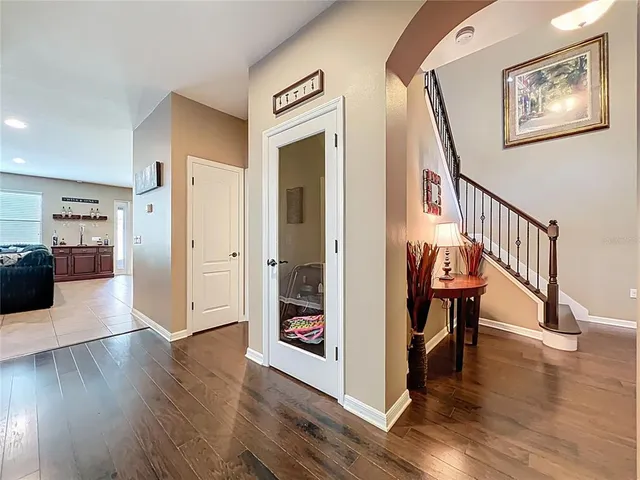 a view of a hallway with wooden floor and furniture