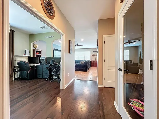 a view of a hallway with wooden floor and furniture
