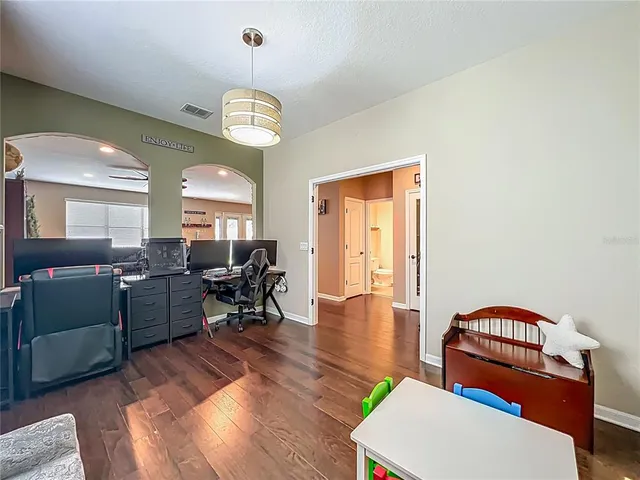 a living room with furniture a dining table a lamp and a window