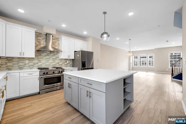a kitchen with a stove window and wooden floor